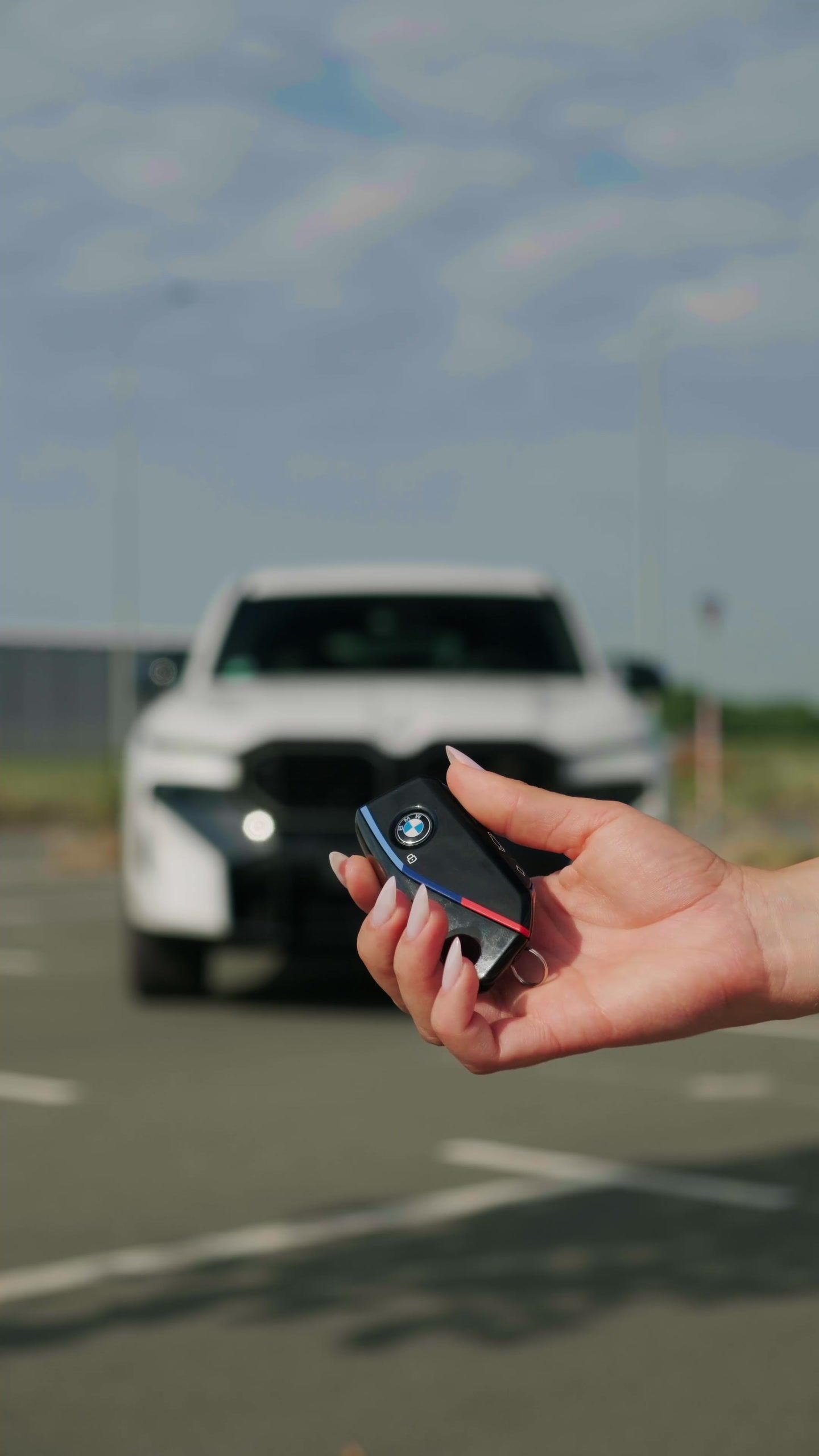 Ključ u ruci ispred belog BMW XM